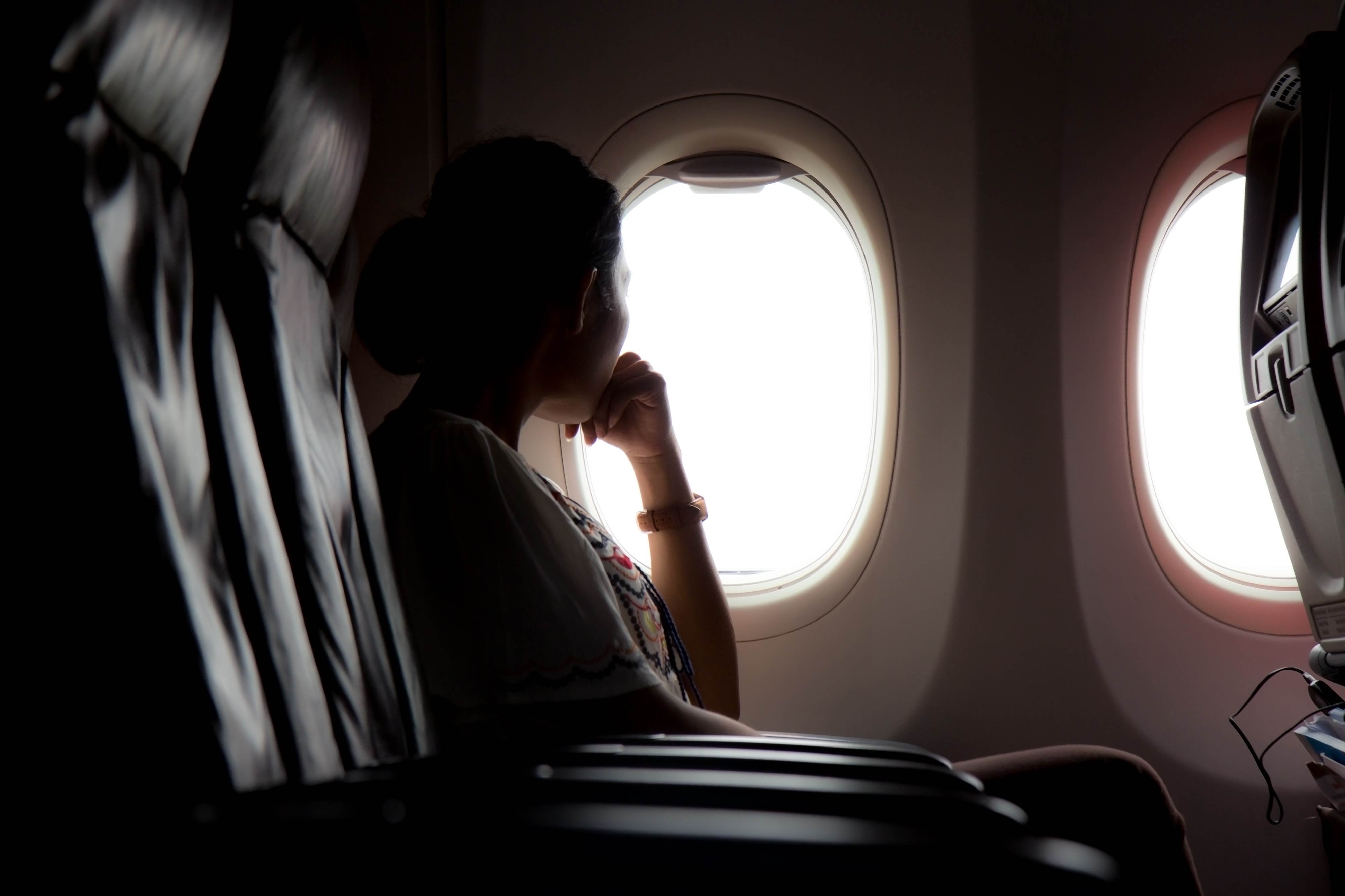 Страх полета на самолете. Девушка в самолете. Девушка в самолете у окна. Человек в иллюминаторе. Фотосессия с самолетом.