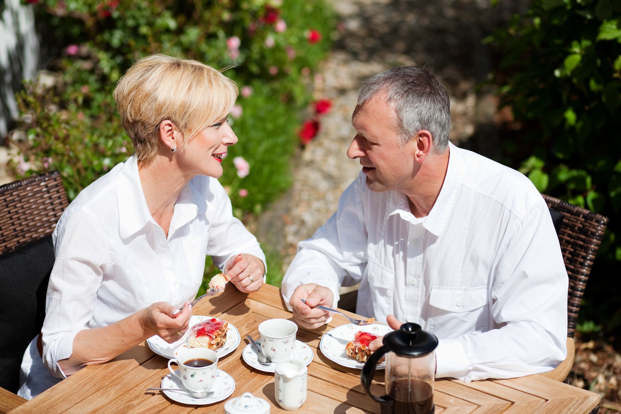 Взрослый сын пьет. Пожилая пара за столиком кафе. Пожилые мужчина и женщина пьют чай. Фотосессия пожилой пары в кафе. Пенсионеры в саду.